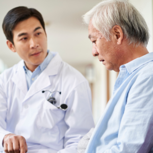 How to prevent recurrent UTI in males: doctor reassures older male patient with a hand on his shoulder in a clinic